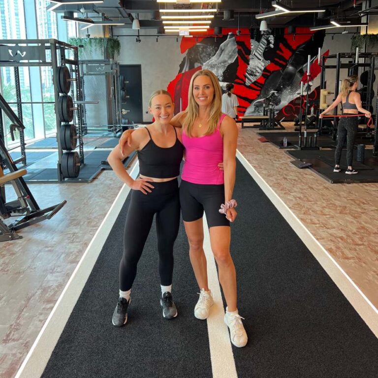 Alice Liveing standing with a ROAR trainer on the training track at ROAR Fitness Dubai