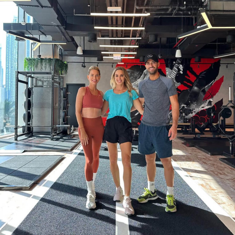 Caroline and Sergio standing with a ROAR trainer on the training track at ROAR Fitness