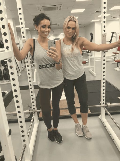 Christine Lampard and her personal trainer in a mirror selfie beside a squat rack at ROAR Fitness London
