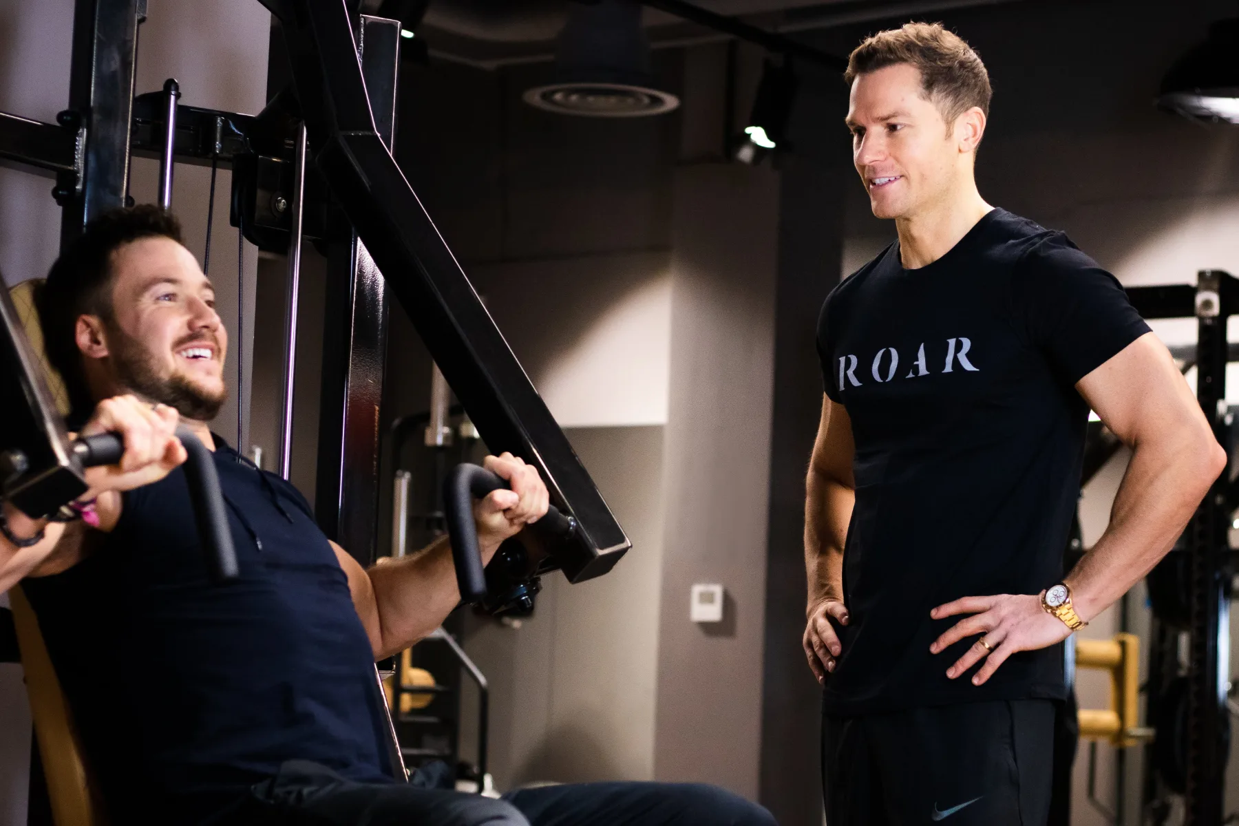 Client on the chest press with his Roar Fitness personal trainer beside him