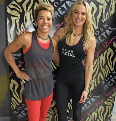 Dame Kelly Holmes with Sarah Lindsay in front of a ROAR Metal banner at ROAR Fitness London
