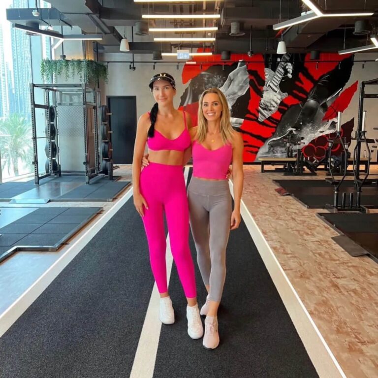 Debbie Wingham in pink gym kit standing with a ROAR trainer on the training track at ROAR Fitness