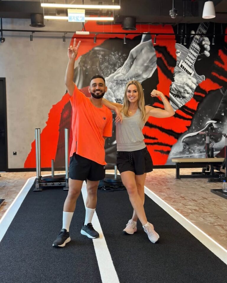 DJ Bliss making a peace sign beside a ROAR trainer on the training track at ROAR Fitness Dubai