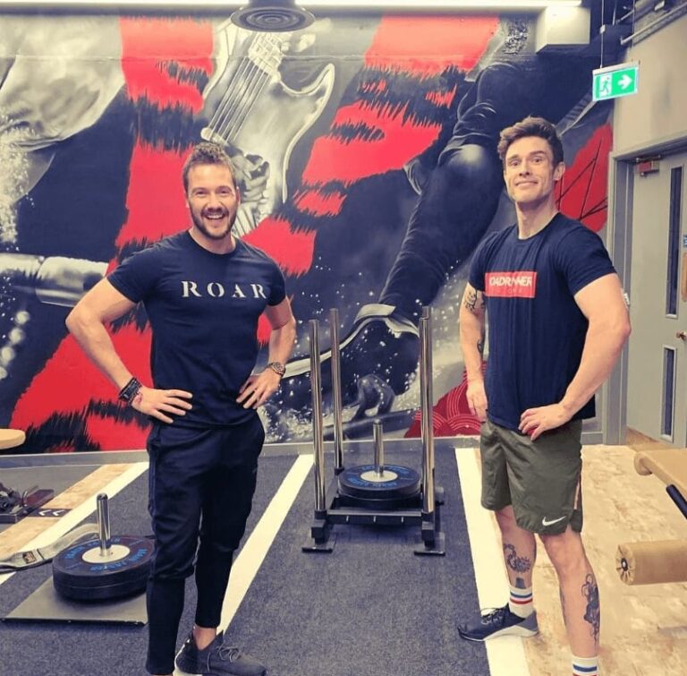 Ed Gamble and ROAR trainer Jack Pressling standing either side of a sled at ROAR Fitness