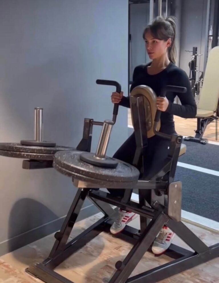 Emma Louise Connelly training on a plate-loaded machine during a full-body session at ROAR Fitness