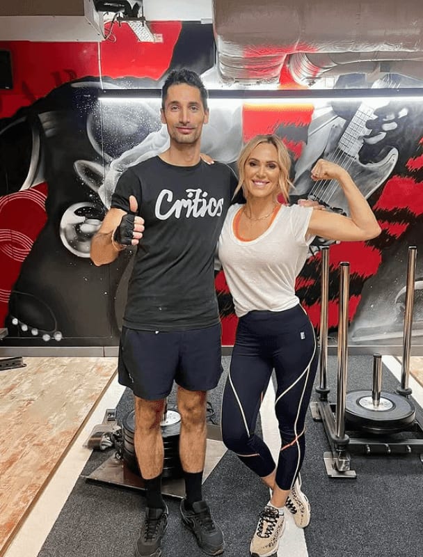 Hugo Taylor giving a thumbs up next to Sarah Lindsay, who is flexing her arm, at ROAR Fitness