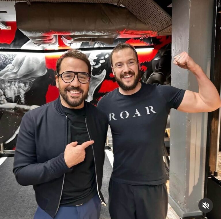 Jeremy Piven pointing at a ROAR personal trainer who is flexing his arm, at ROAR Fitness London