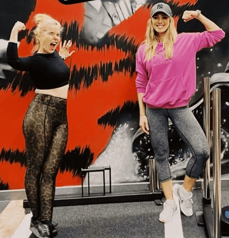 Paloma Faith and Sarah Lindsay flexing in front of the tiger mural at ROAR Fitness