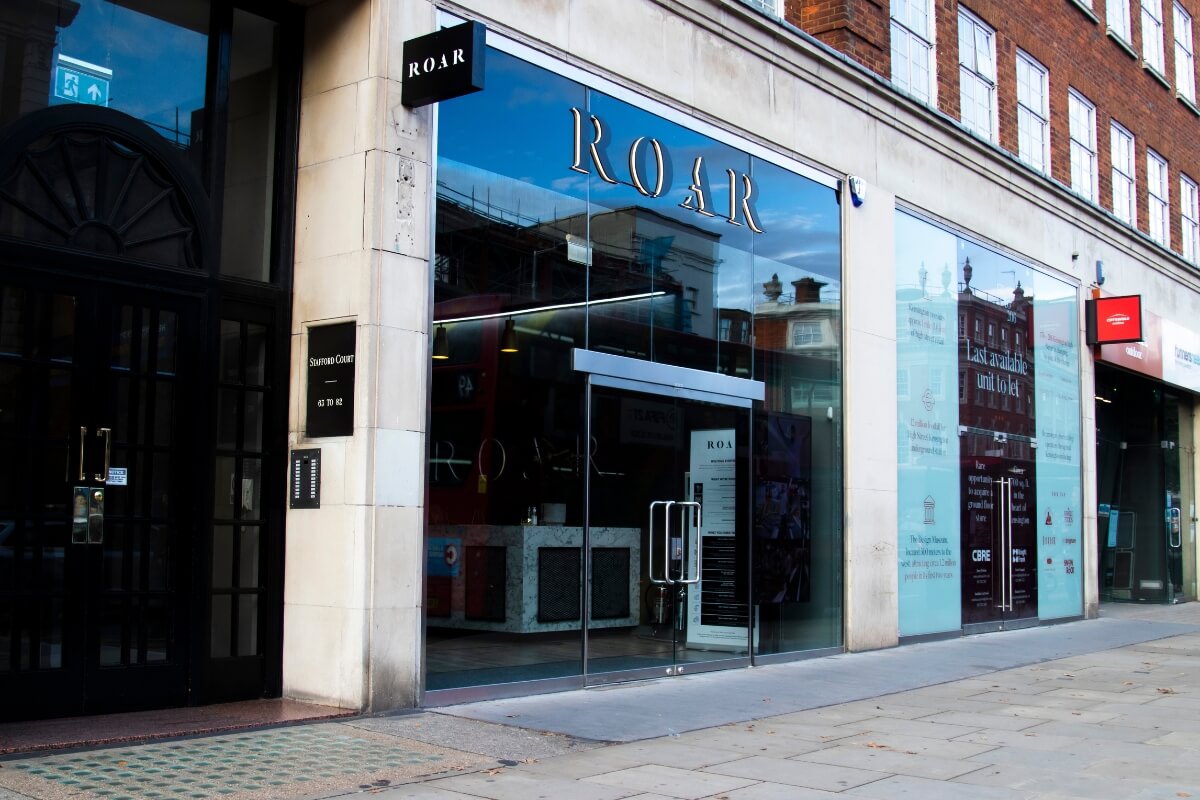 Street view of the ROAR Fitness Kensington gym entrance with illuminated ROAR signage on a glass frontage