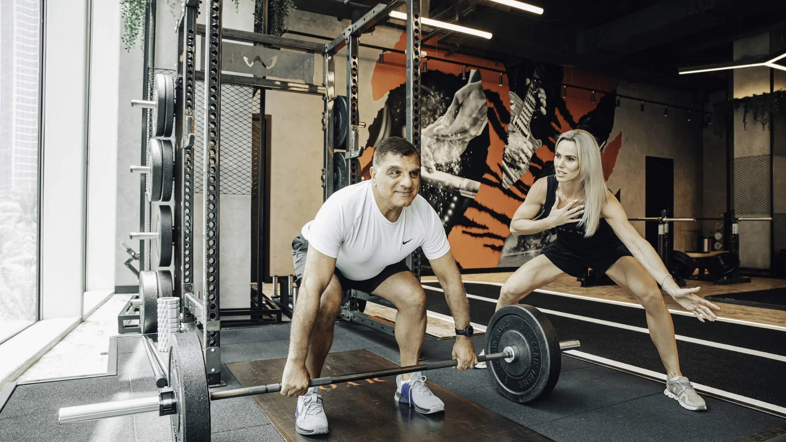 Sarah Lindsay coaching a client through a barbell deadlift at Roar Fitness
