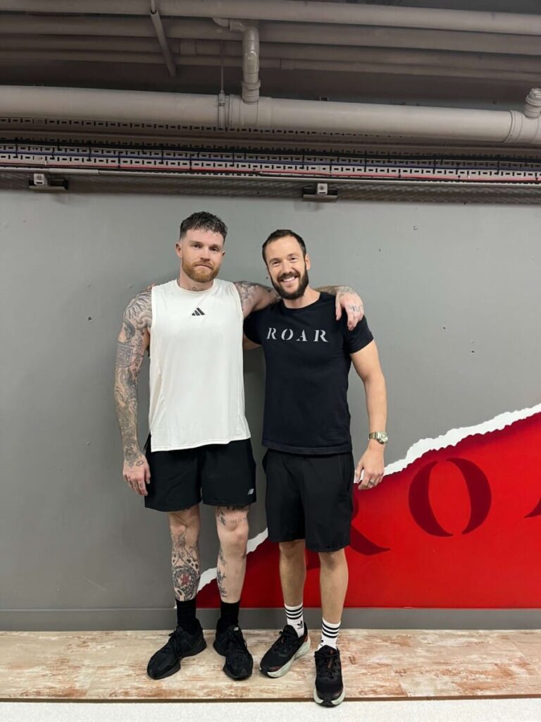 Tom Brown standing with his ROAR personal trainer at ROAR Fitness London